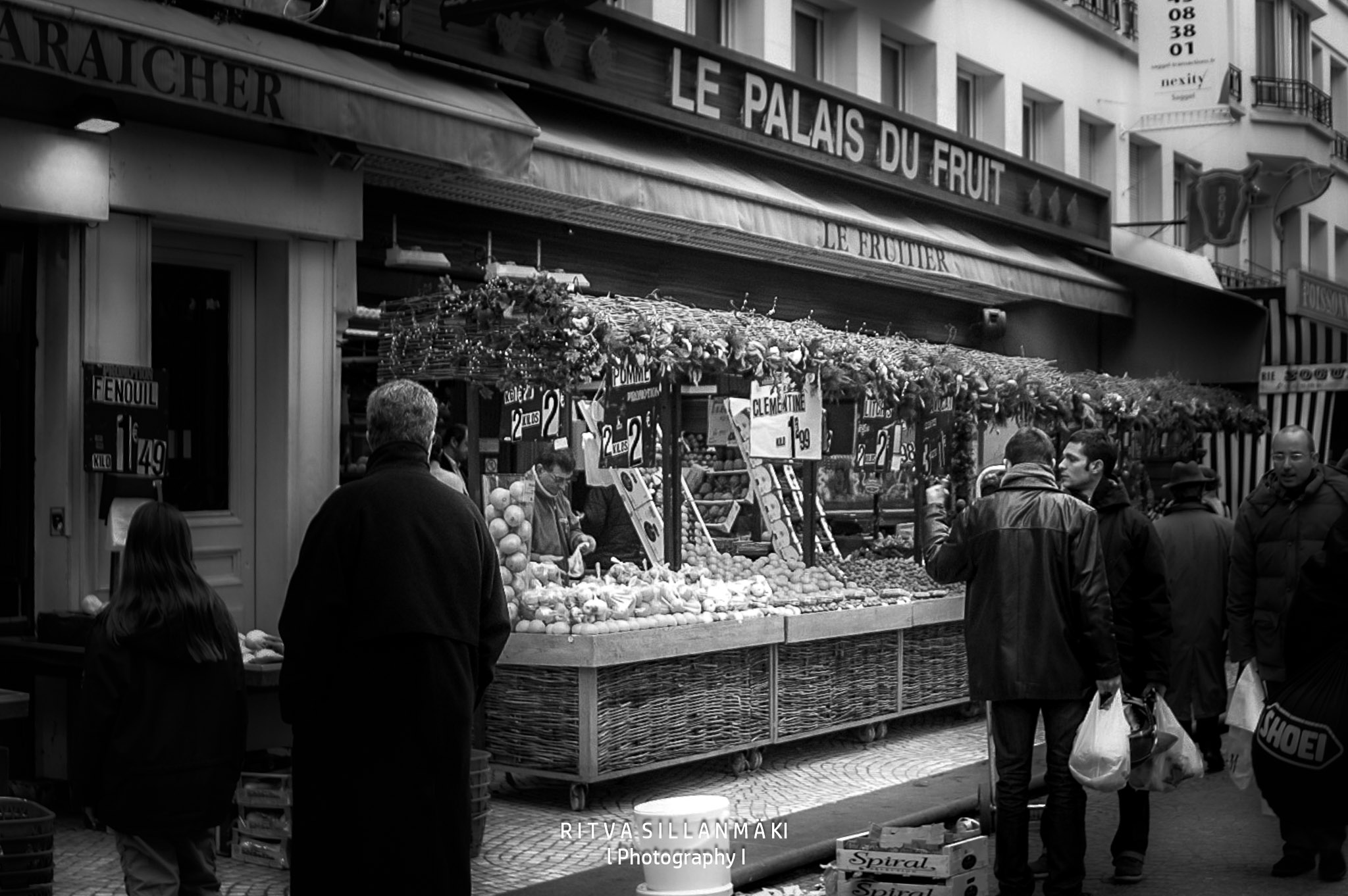 KShoppers browse colorful produce at Le Palais du Fruit, a lively French street market.ONICA MINOLTA DIGITAL CAMERA