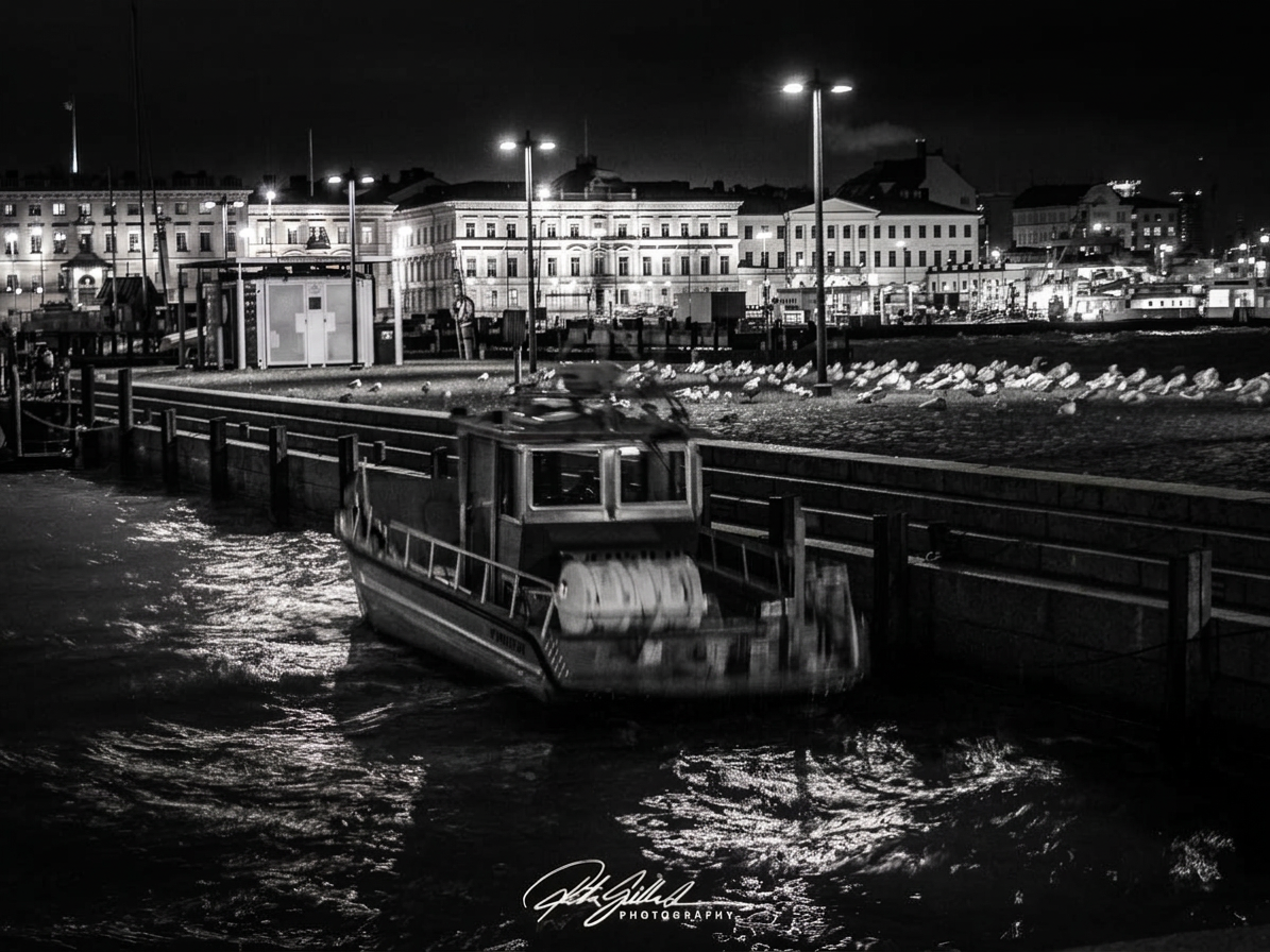 Helsinki waterfront ferry beneath historic harbor lights